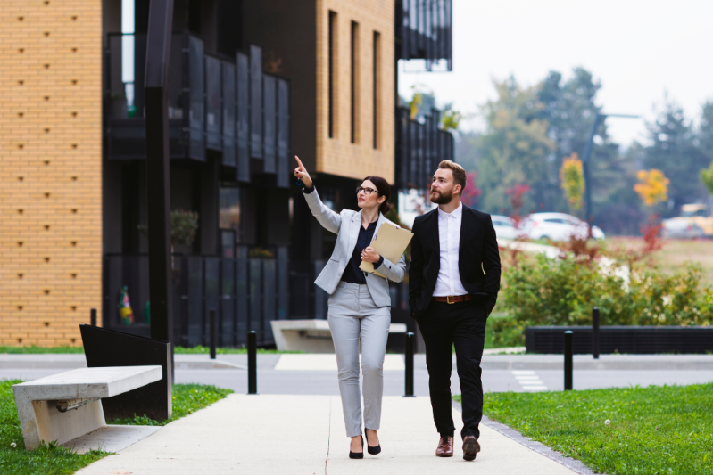Business man and woman walking in front of a building